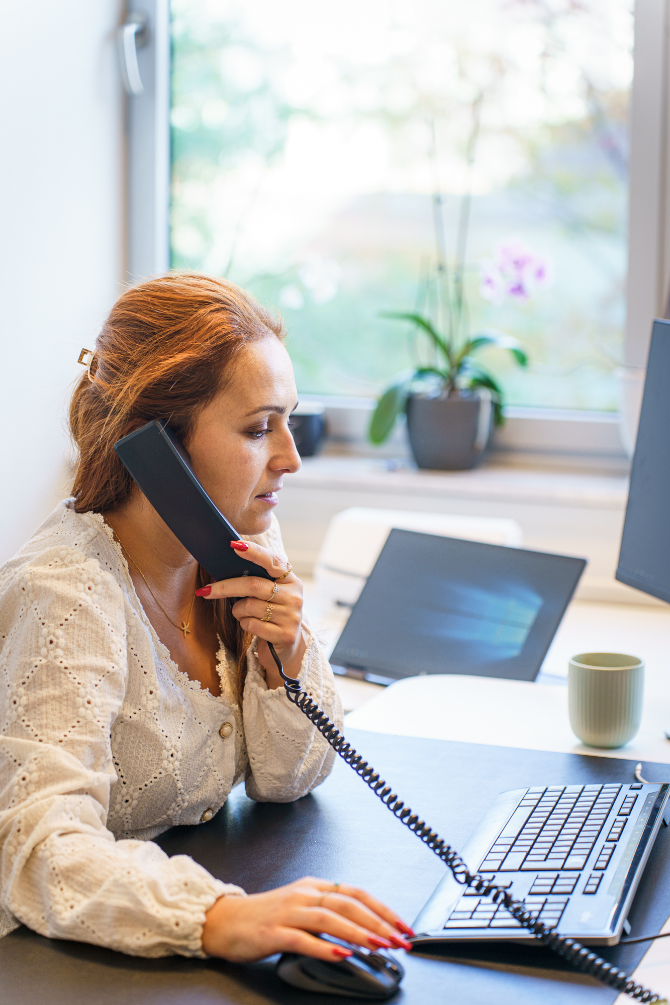 Sachbearbeiterin im Kundenservice telefoniert am Arbeitsplatz
