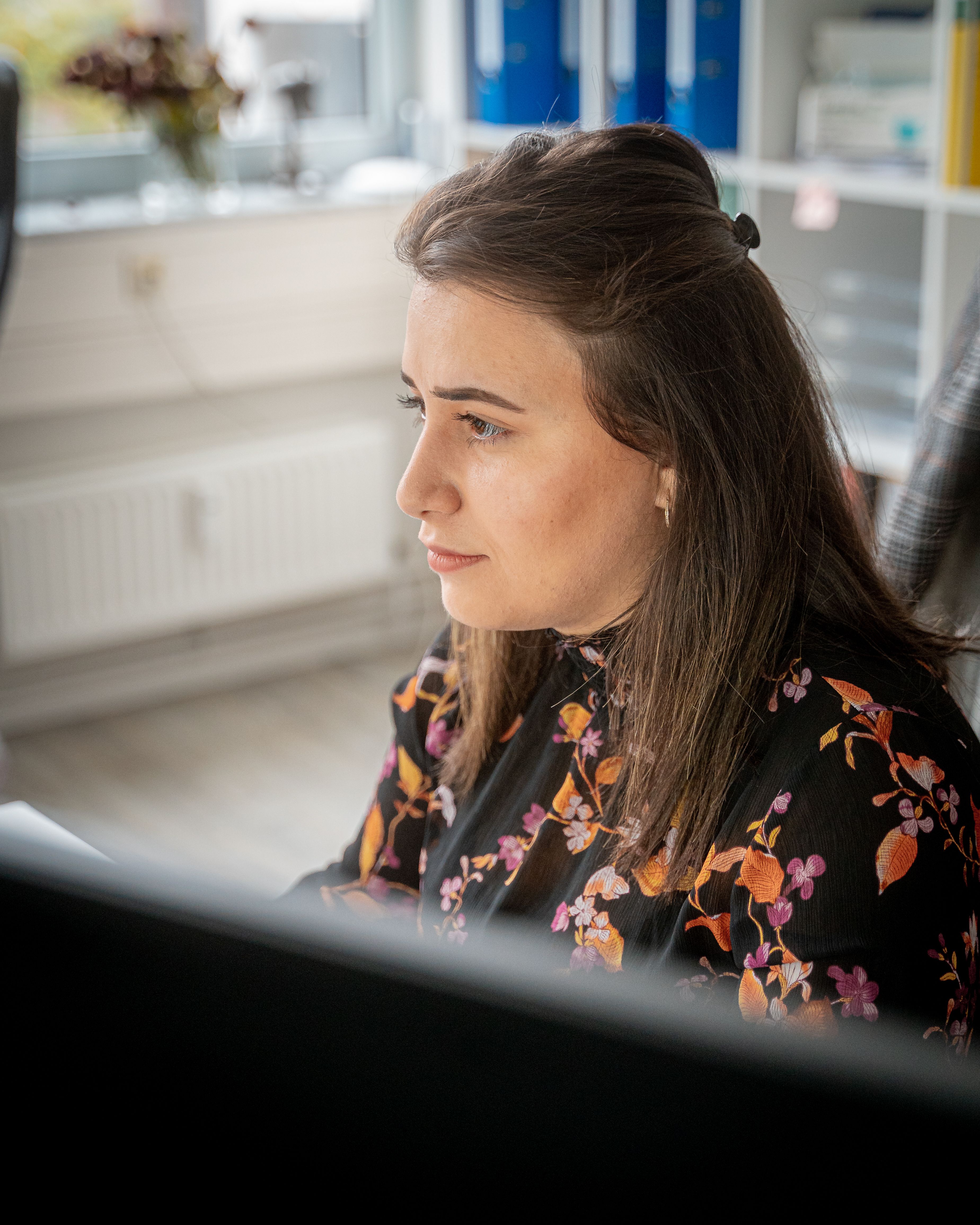 Mitarbeiterin arbeitet konzentriert am Computer