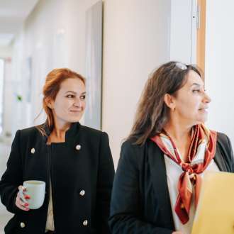 Zwei Mitarbeiterinnen im Gespräch auf dem Flur