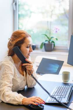 Sachbearbeiterin im Kundenservice telefoniert am Arbeitsplatz